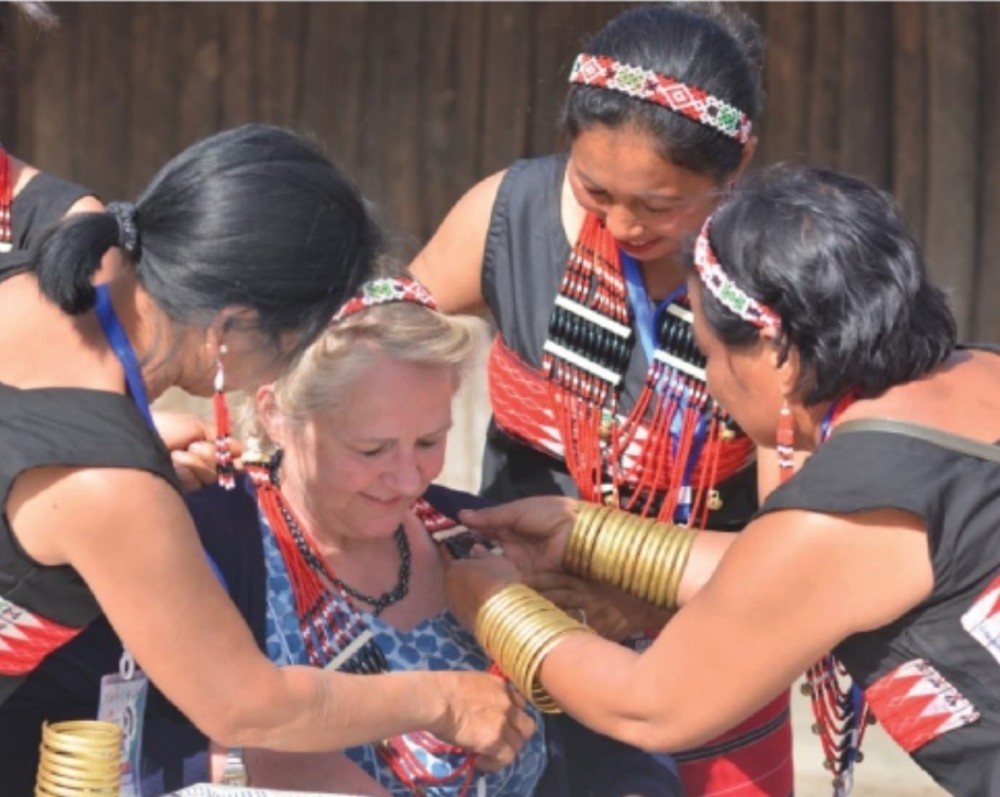 A tourist is seen trying out ornaments with a group of Naga women in one of the traditional Morungs in this picture taken during the Hornbill Festival on December 2, 2018 at the Naga Heritage Village, Kisama near Kohima. (Morung File Photo)